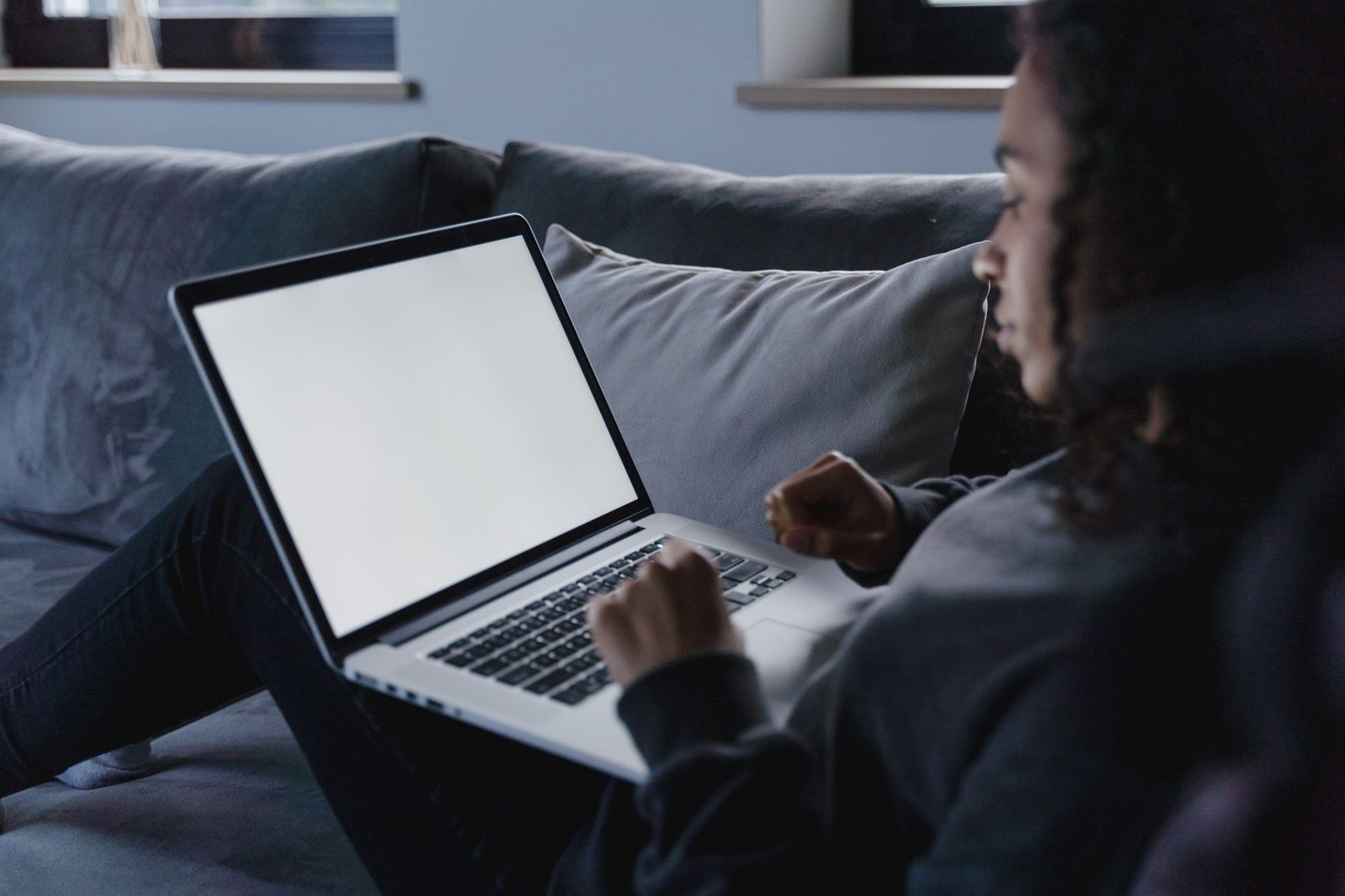 Person using laptop on sofa for device configuration